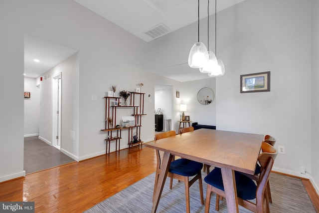 dining room featuring visible vents, baseboards, and wood finished floors