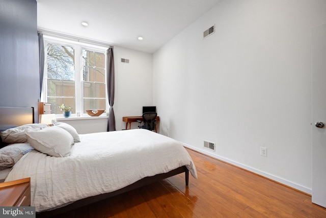 bedroom with wood finished floors and visible vents