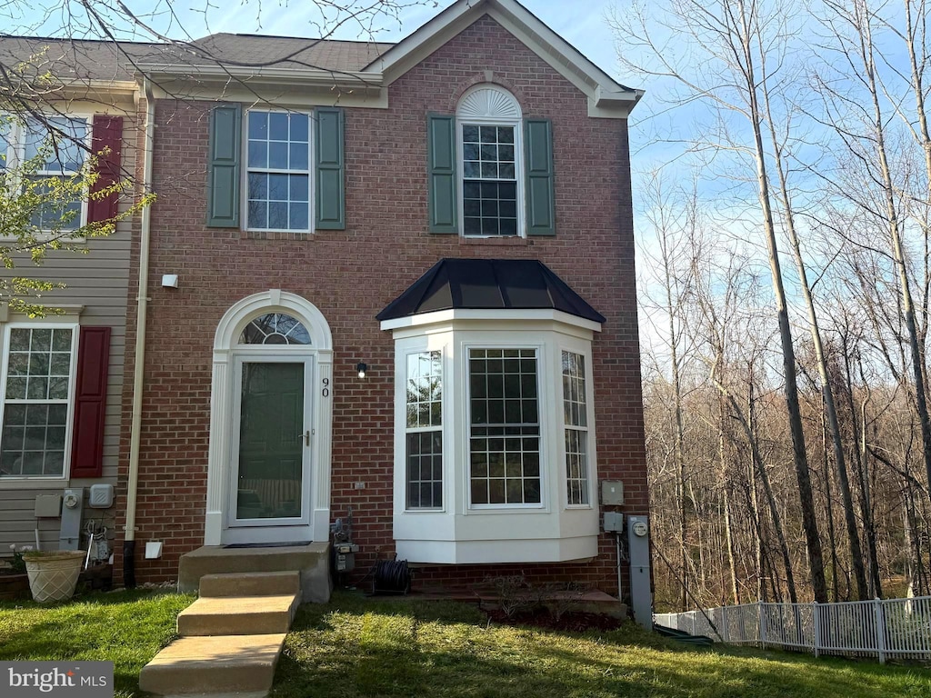 view of front of property featuring brick siding and fence