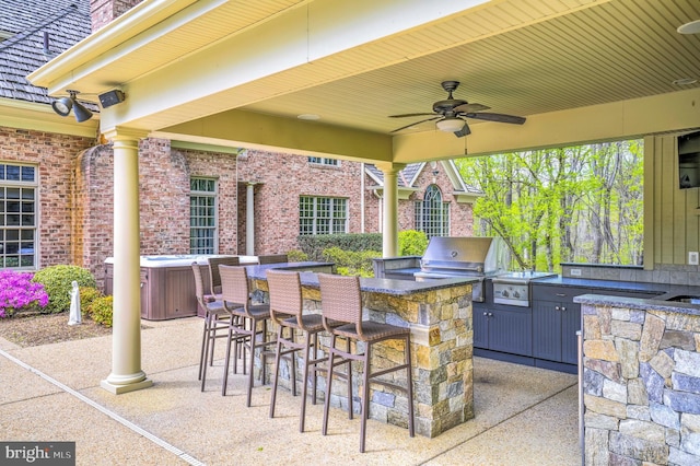 view of patio featuring grilling area, outdoor wet bar, an outdoor kitchen, and ceiling fan