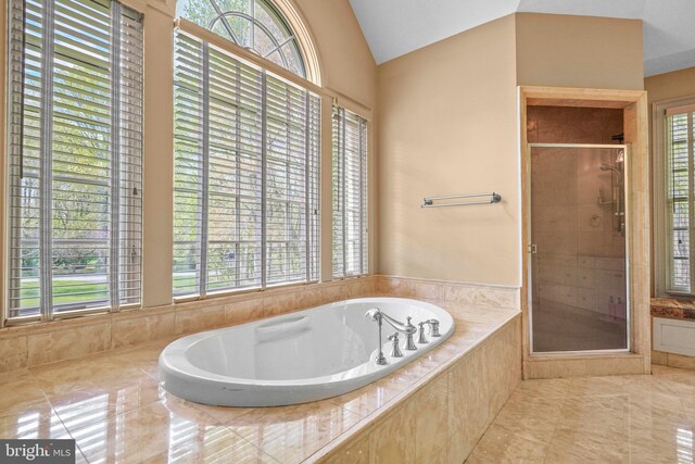 bathroom featuring a garden tub, vaulted ceiling, and a shower stall