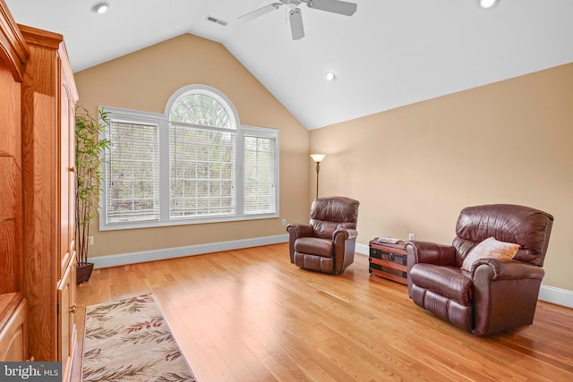 living area featuring lofted ceiling, wood finished floors, visible vents, a ceiling fan, and baseboards
