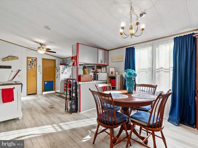 27689 Hartford Ct, Millsboro, DE 19966 - dining area with light wood-style floors, lofted ceiling, a textured ceiling, and ceiling fan with notable chandelier