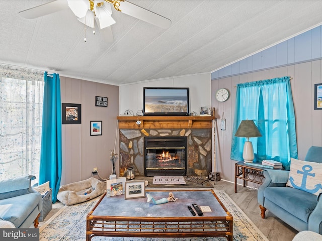 27689 Hartford Ct, Millsboro, DE 19966 - living room with lofted ceiling, a ceiling fan, wood finished floors, a stone fireplace, and ornamental molding