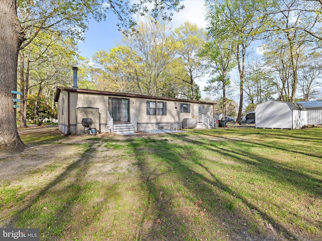 27689 Hartford Ct, Millsboro, DE 19966 - rear view of property featuring an outdoor structure, entry steps, a yard, and a shed