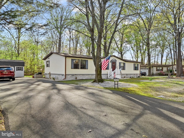 27689 Hartford Ct, Millsboro, DE 19966 - manufactured / mobile home featuring entry steps, a shed, crawl space, an outdoor structure, and driveway