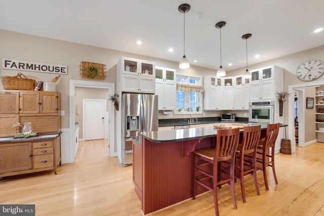 34844 Apple Pride Ct, Round Hill, VA 20141 - kitchen featuring stainless steel appliances, light wood-style flooring, a sink, and glass insert cabinets