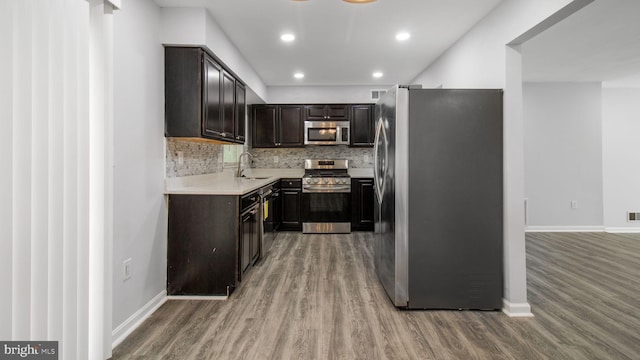 11400 Cosca Park Pl, Clinton, MD 20735 - kitchen featuring baseboards, decorative backsplash, stainless steel appliances, a sink, and wood finished floors