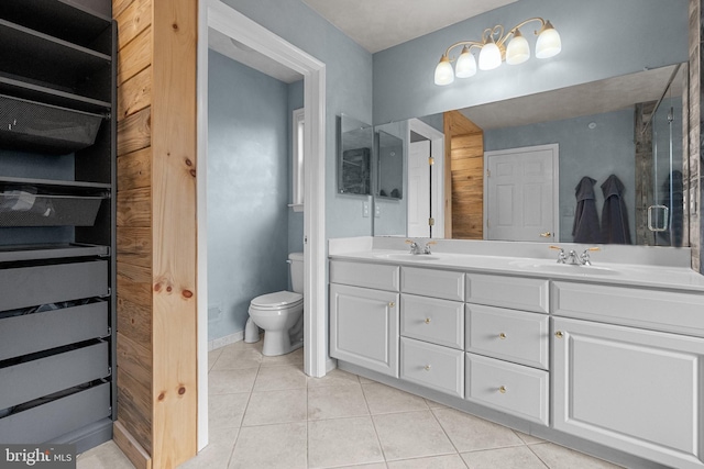 bathroom featuring a sink, tile patterned floors, double vanity, and toilet