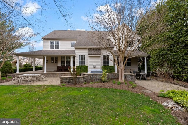 rear view of house featuring a patio area, roof with shingles, an outdoor fire pit, and a lawn