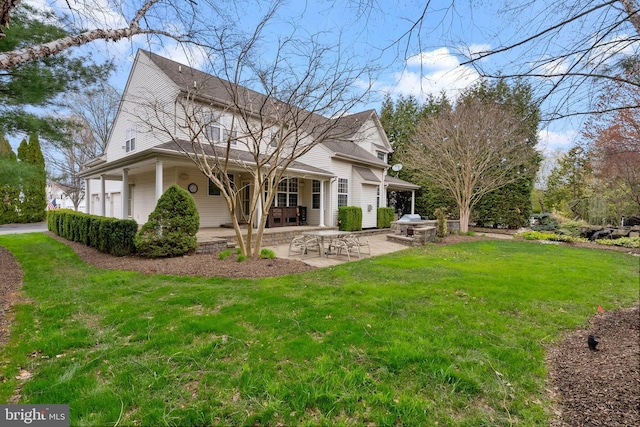 rear view of house with a patio and a yard