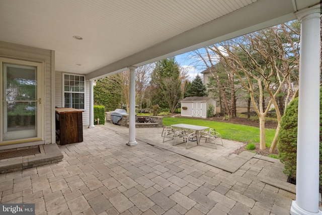 view of patio / terrace with outdoor dining space, an outdoor structure, and a storage unit