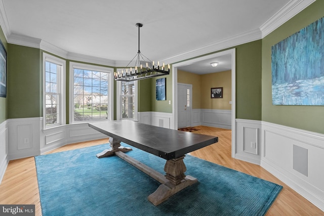 recreation room with a chandelier, crown molding, wainscoting, and light wood-type flooring
