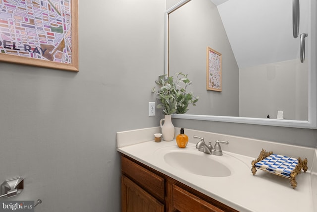 bathroom featuring vanity and lofted ceiling