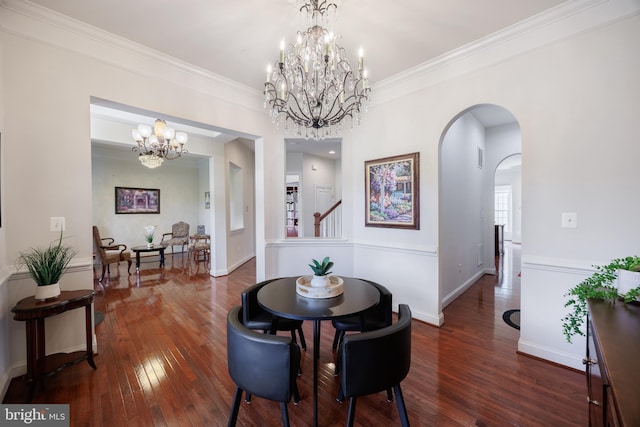 dining space with arched walkways, baseboards, hardwood / wood-style flooring, and a notable chandelier
