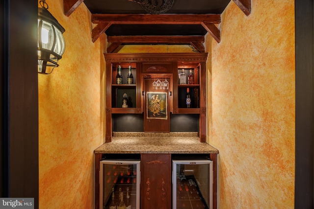 interior space with beamed ceiling, a textured wall, a dry bar, and wine cooler