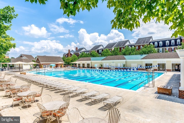 pool with fence, a patio area, and a residential view