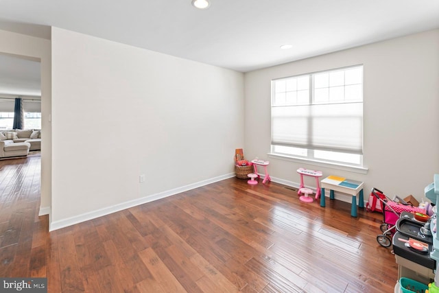 recreation room with baseboards, wood-type flooring, and recessed lighting