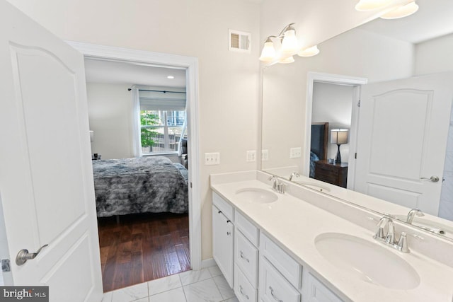 ensuite bathroom featuring a sink, ensuite bathroom, double vanity, and visible vents