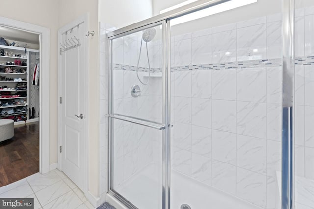 bathroom featuring a walk in closet and a stall shower