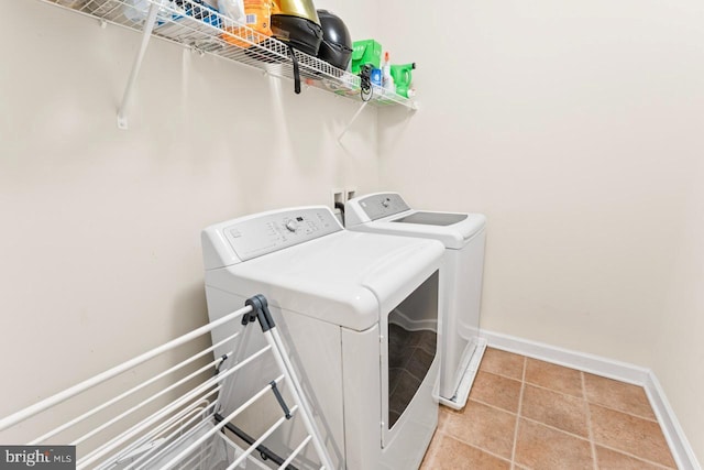 clothes washing area featuring independent washer and dryer, laundry area, and baseboards