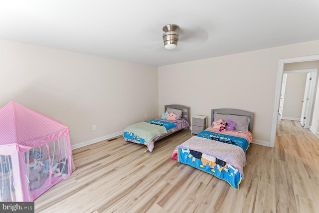 bedroom featuring baseboards, visible vents, and wood finished floors