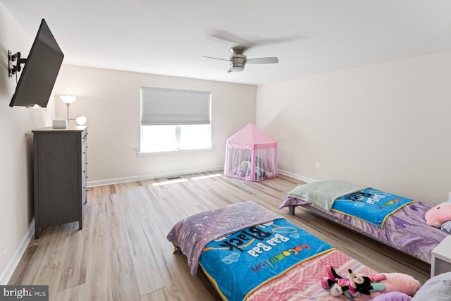 bedroom featuring a ceiling fan, baseboards, and wood finished floors