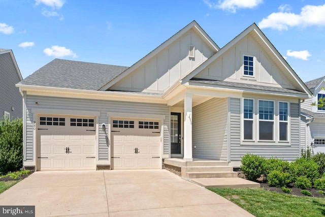 view of front of house featuring a garage, board and batten siding, concrete driveway, and roof with shingles