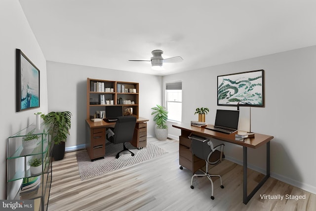 home office featuring a ceiling fan, baseboards, and light wood-type flooring