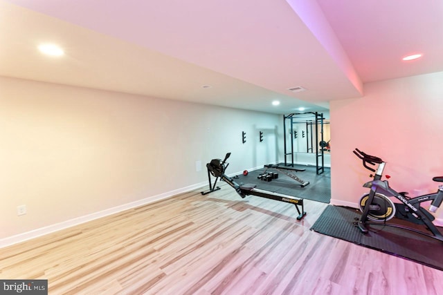 exercise room featuring baseboards, recessed lighting, wood finished floors, and visible vents