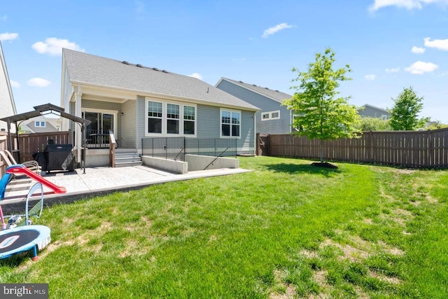 back of house with a fenced backyard, a patio area, and a yard