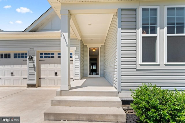 entrance to property featuring an attached garage and driveway