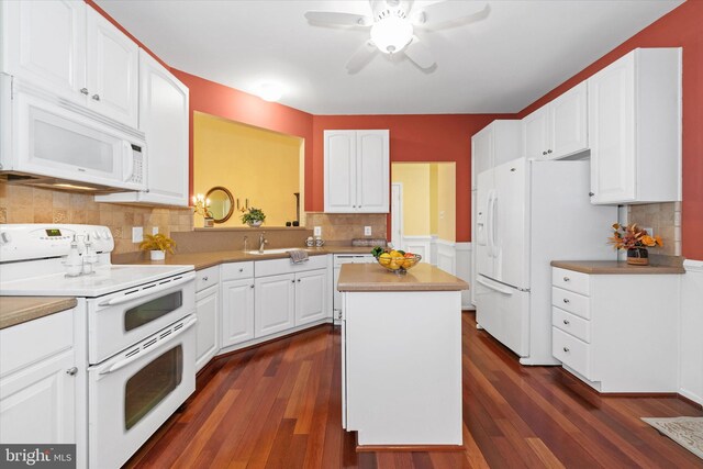 kitchen with a sink, dark wood finished floors, ceiling fan, and white appliances