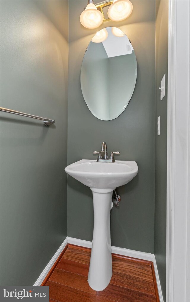 bathroom with a sink, wood finished floors, and baseboards