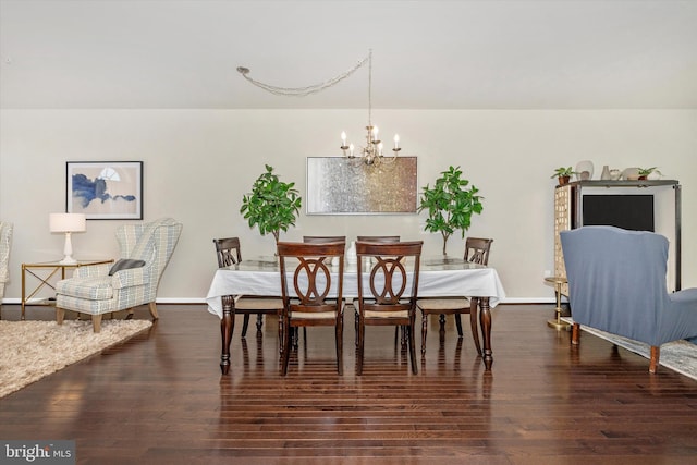 dining area with wood finished floors, a chandelier, and baseboards