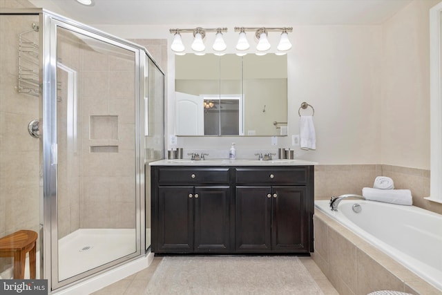 bathroom featuring a sink, double vanity, a stall shower, tile patterned floors, and a garden tub