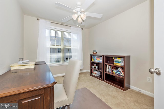 office with a ceiling fan, baseboards, and light carpet