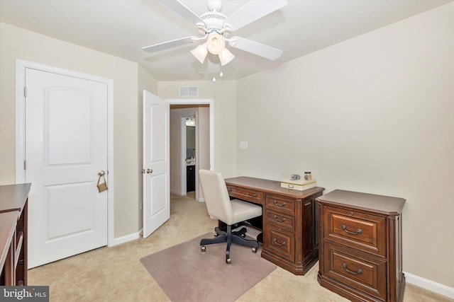 office featuring a ceiling fan, visible vents, light carpet, and baseboards