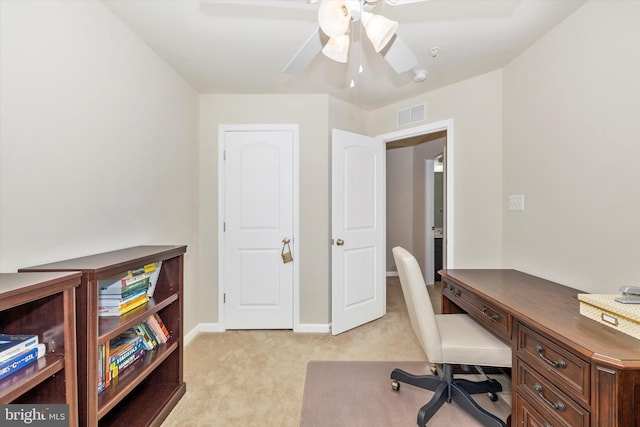 office area featuring baseboards, visible vents, a ceiling fan, and light colored carpet