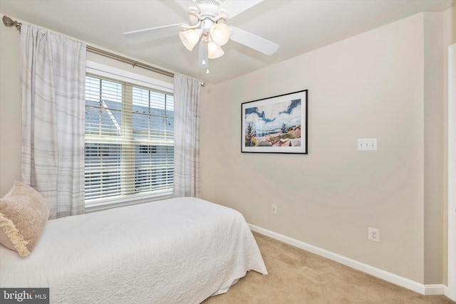 bedroom with baseboards, a ceiling fan, and light colored carpet