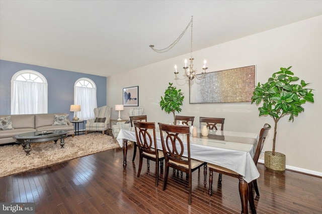 dining room with dark wood finished floors, baseboards, and an inviting chandelier