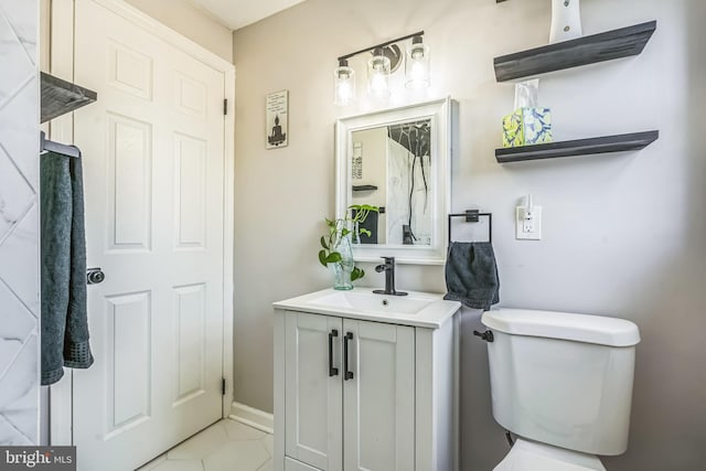 bathroom featuring toilet, tile patterned flooring, and vanity