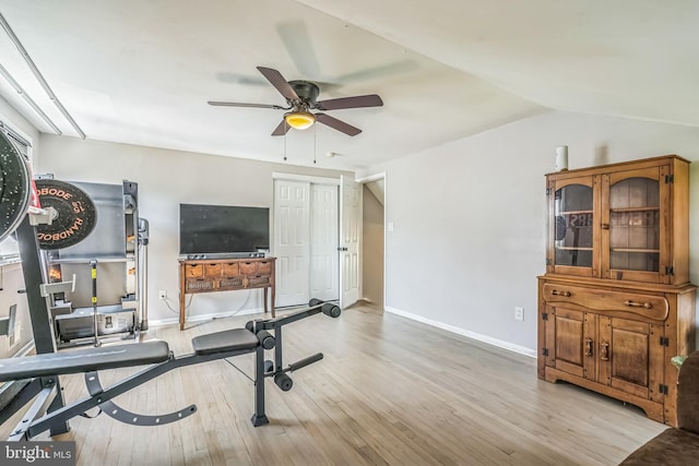 workout room with baseboards, a ceiling fan, and wood finished floors