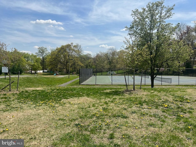 exterior space with a tennis court and fence