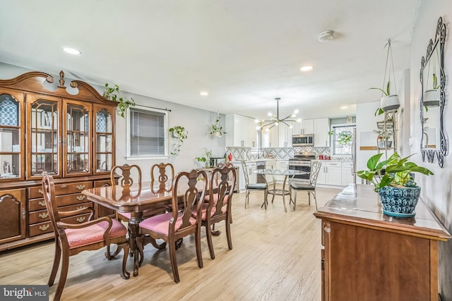 dining space with recessed lighting, a chandelier, and light wood-style flooring