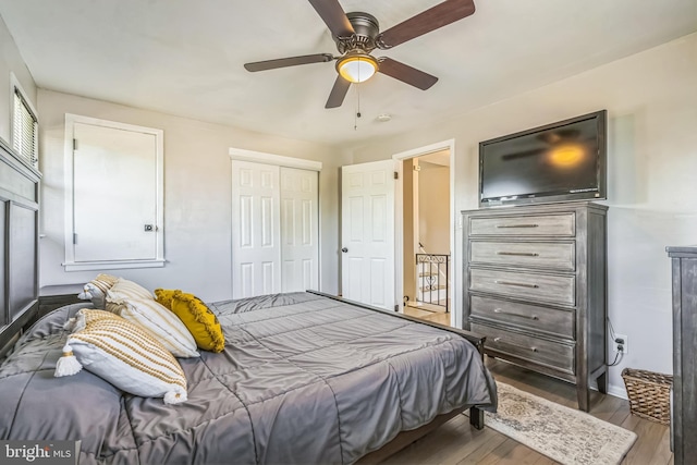 bedroom with baseboards, a ceiling fan, a closet, and wood finished floors