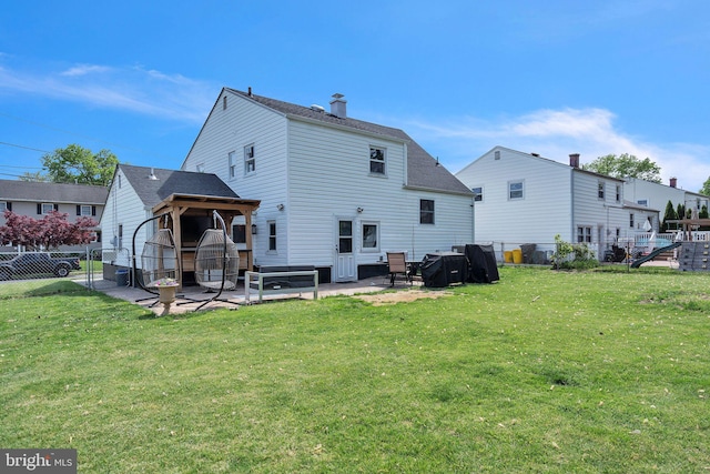 back of house featuring a fenced backyard, a chimney, a shingled roof, a patio area, and a lawn