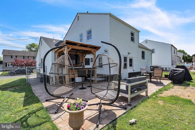 rear view of house featuring fence, a gate, a yard, and a patio area