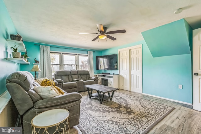 living room with baseboards, a ceiling fan, and wood finished floors