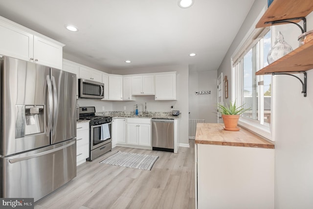 kitchen featuring a sink, butcher block countertops, appliances with stainless steel finishes, and recessed lighting